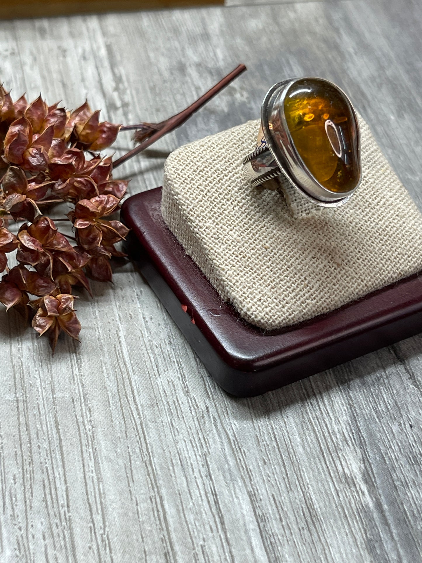 Amber ring with tiny footprint behind sz 6