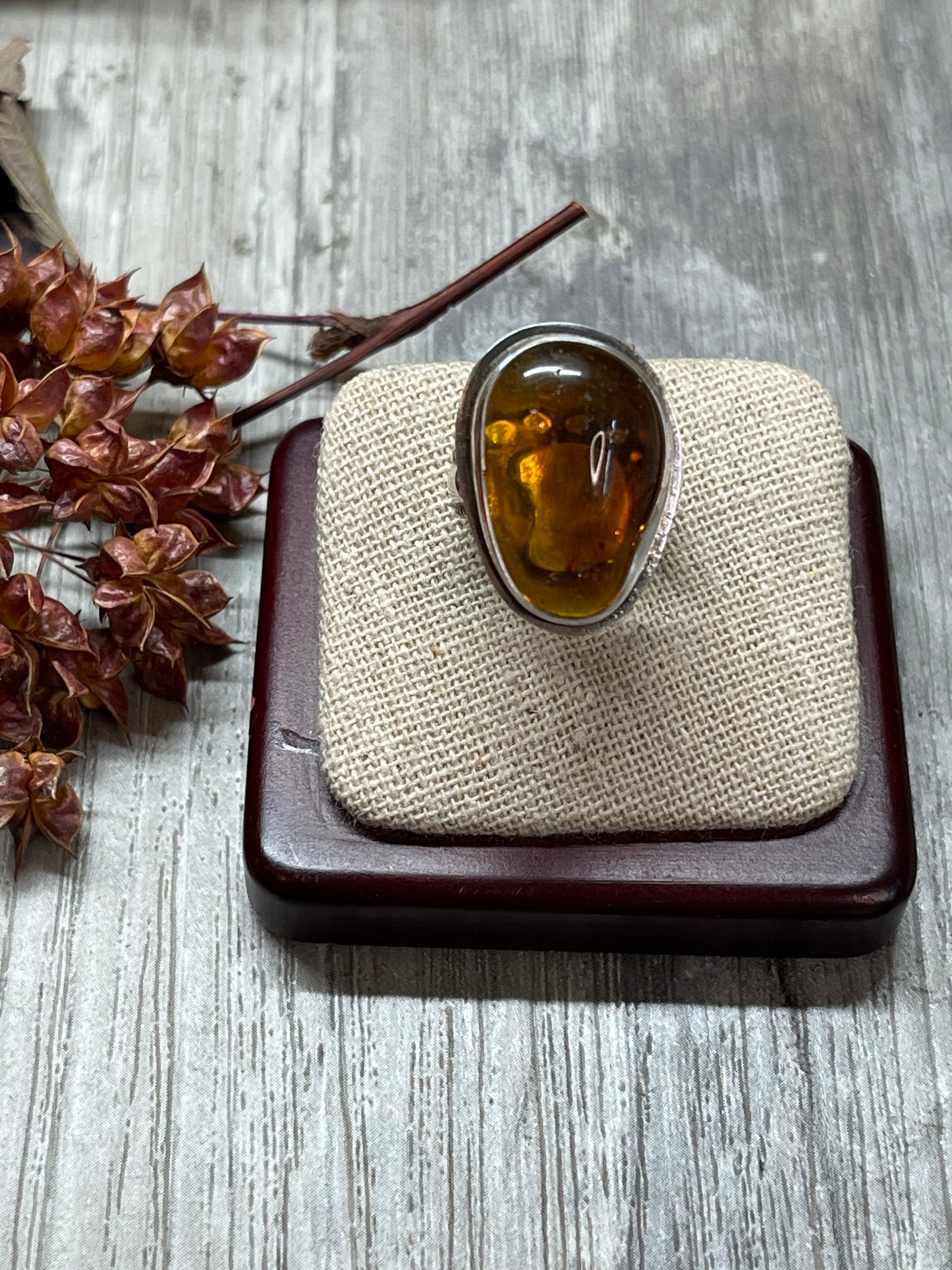 Amber ring with tiny footprint behind sz 6