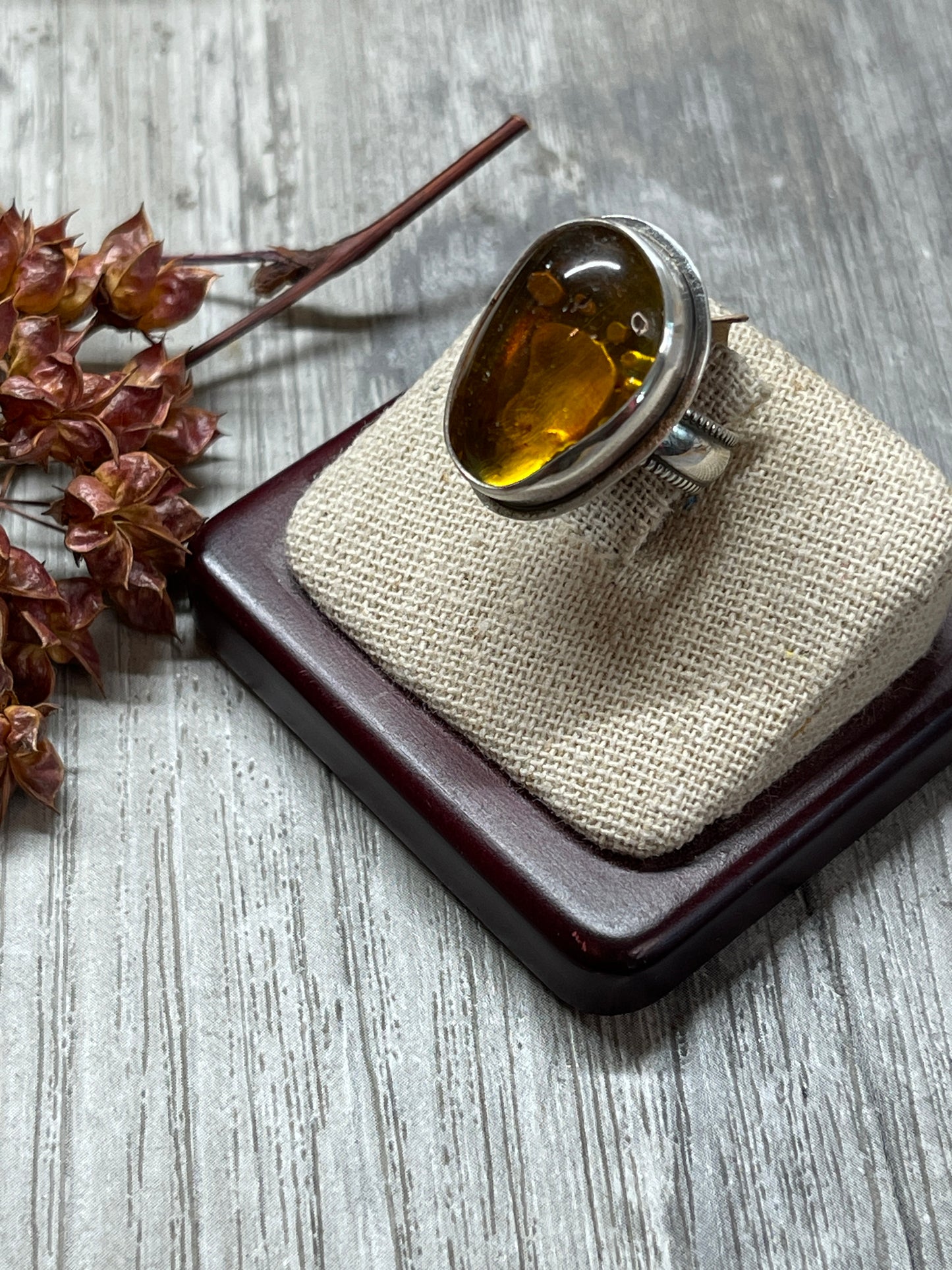 Amber ring with tiny footprint behind sz 6